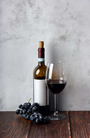 Wine bottles with glass and grape on wooden background.の写真素材