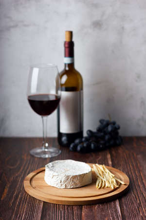 Still life of wine, cheese and grapes on wooden table.の写真素材