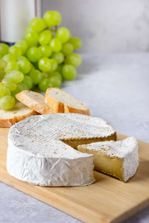 Camembert with green grapes and wine bottle. Appetizer selection.の写真素材