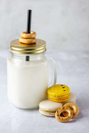 Baked bagels, macaroon and milk in mason jar on the table.の写真素材