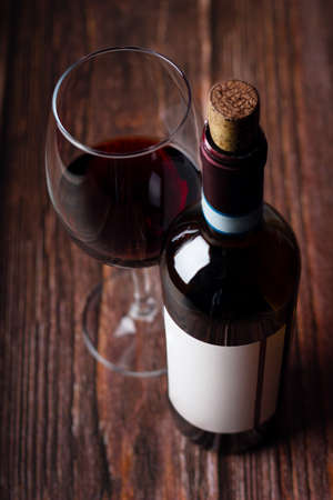 Red wine glasses and bottle on wooden backgroundの写真素材