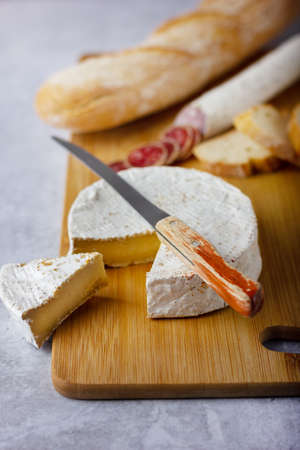 Spanish sausages cut in slices and cheese camembert on a wood boardの写真素材
