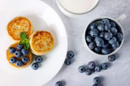 Cottage cheese pancakes, syrniki with blueberry in a white plate.の写真素材