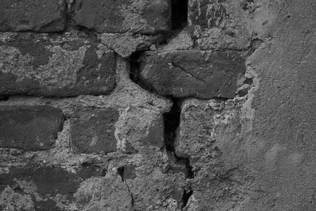 Cracked brick wall with peeling plaster. black and white photography.の写真素材