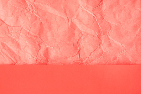 Trendy coral colored textured background. Crumpled orange-pink craft paper and plain paper sheets divided creating line partition. Flat lay.の写真素材