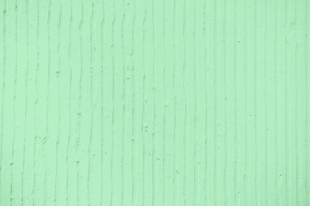 Closeup of the wall with a decorativetrendy colored mint plaster vertical lines and stripes....