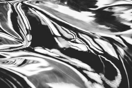 Abstract black and white fluid art background. Real holographic metallic foil texture with scratches and irregularities.の写真素材