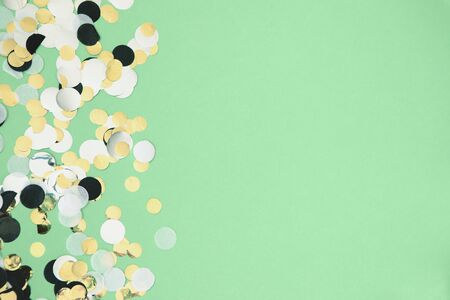 Gold, silver, black and white foil confetti sparse on trendy mint colored background. Simple holiday concept. Design template. Copy space for text. Top view, flat layの写真素材