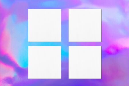 Four empty white square flyer or business card mock ups with soft shadows on holographic background. Flat lay, top viewの写真素材
