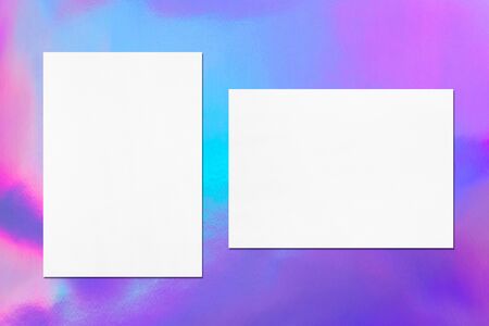 Two empty white vertical and horizontal rectangle poster mock up with soft shadow on holographic...