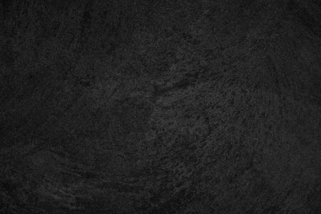 Black low contrast concrete textured wall background with roughness and irregularities to your...