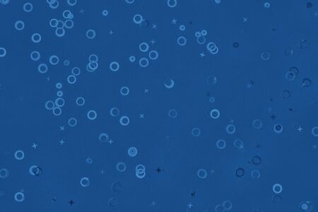 Monochrome metallic foil confetti background. Trendy blue colored circles and stars sparse on dark...