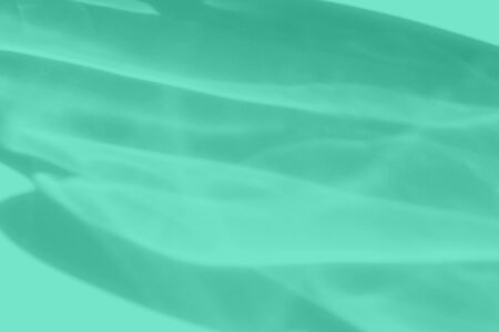 Trendy mint colored abstract background with light and shadows caustic effect. Light passes through a glass. 2020 year color trendの写真素材