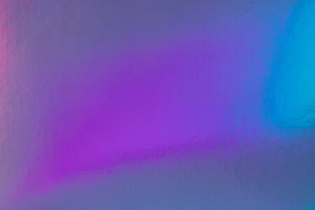 Abstract trendy rainbow holographic background in 80s style. Blurred texture in violet, pink and mint colors with scratches and irregularities. Bright neon colors.の写真素材