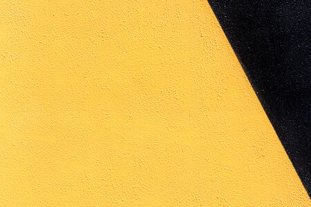 Closeup of duo colored black and yellow urban wall texture. Modern pattern for wallpaper design. Creative urban city background. Abstract open composition. Minimal geometric style, solid colorsの写真素材
