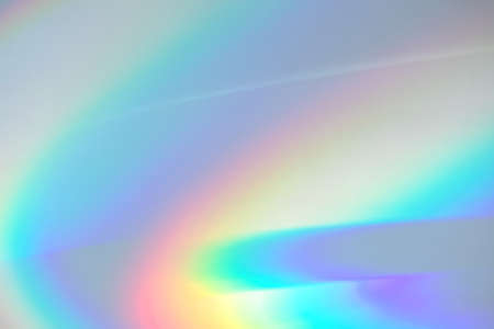 Blurred rainbow light refraction texture on white wallの写真素材