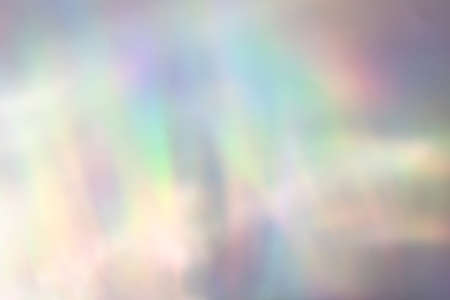 Blurred rainbow light refraction texture on white wall