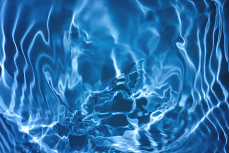 transparent dark blue colored clear calm water surface textureの写真素材