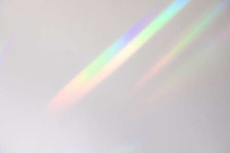 Blurred rainbow light refraction texture on white wall