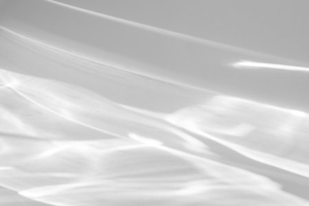 shadow and light caustic effect on a white wallの写真素材