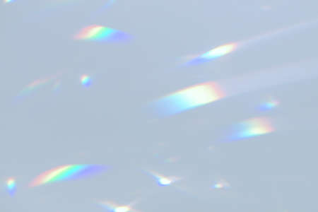 Blurred rainbow light refraction texture on white wall