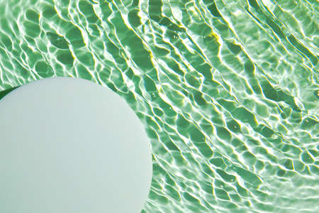 Empty white circle podium on transparent green clear water backgroundの写真素材