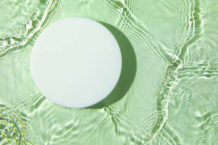 Empty white circle podium on transparent green clear water backgroundの写真素材