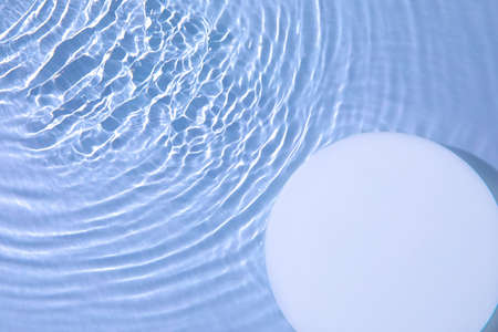 Empty white circle podium on transparent blue water background with copy spaceの写真素材