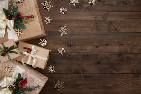 Christmas background with border of gift boxes on dark brown wood backgroundの写真素材