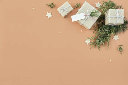 Christmas gift boxes and fir tree on beige backgroundの写真素材