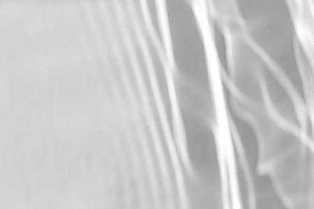 blurred shadow and light caustic effect on a white wallの写真素材