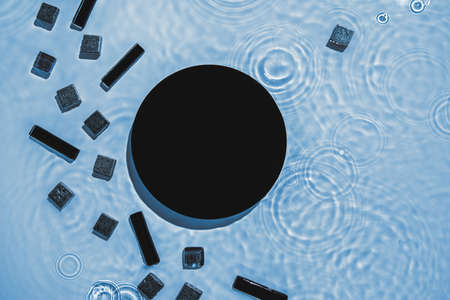 Abstract black geometric figures composition on transparent blue clear waterの写真素材