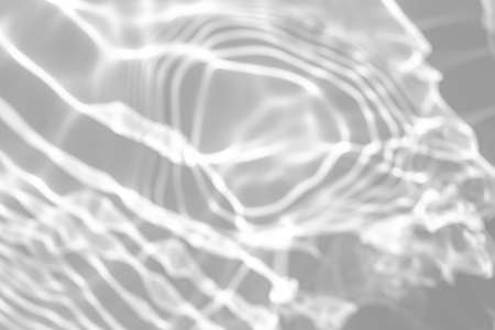 blurred shadow and light caustic effect on a white wallの写真素材