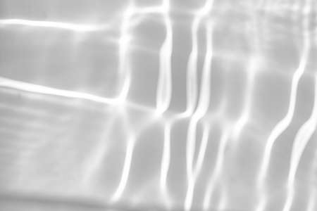 blurred shadow and light caustic effect on a white wallの写真素材