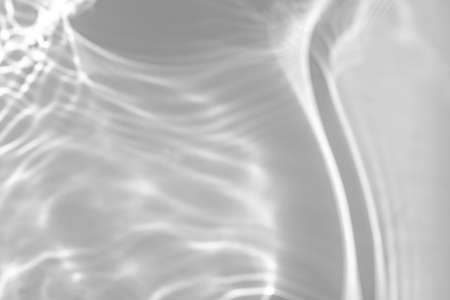 blurred shadow and light caustic effect on a white wallの写真素材