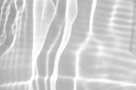 blurred shadow and light caustic effect on a white wallの写真素材