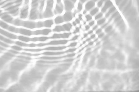 blurred shadow and light caustic effect on a white wallの写真素材