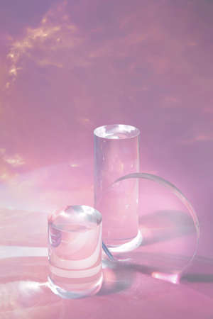 two clear glass cylinder podiums on pastel pink backgroundの写真素材