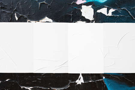 colorful urban wall with four wrinkled glued poster templatesの写真素材