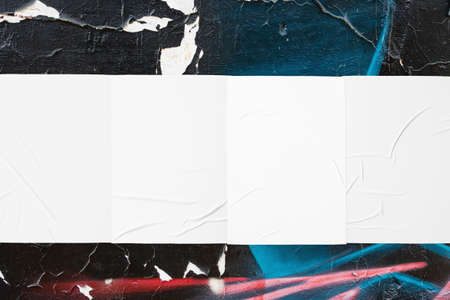 colorful urban wall with four wrinkled glued poster templates