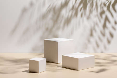 scene with three white podiums on beige backgroundの写真素材