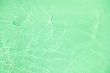 transparent green colored clear calm water surface textureの写真素材