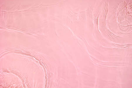 transparent pink colored clear calm water surface textureの写真素材