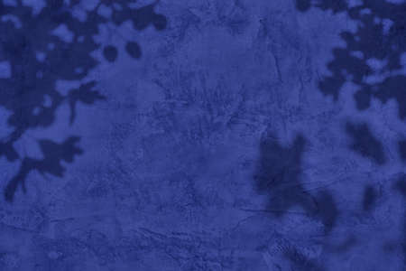 Shadow of leaves on purple concrete wall texture background