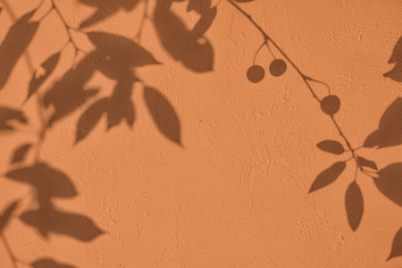 Shadow of leaves on brown concrete wall texture background