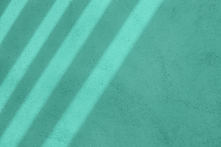Window shadows on mint green concrete wall texture background