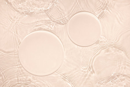 Two empty circle podiums on transparent beige water backgroundの写真素材