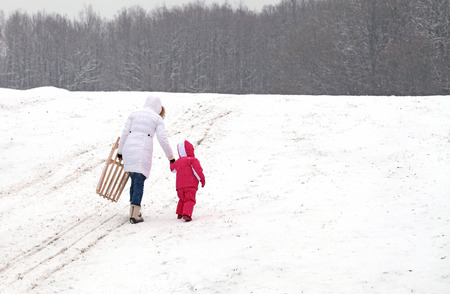 Mother and daughter sledding at winterの写真素材