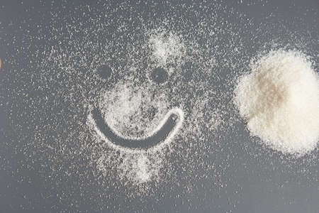 Sugar on a dark background. Diet, sweet life. Smiley face.の写真素材