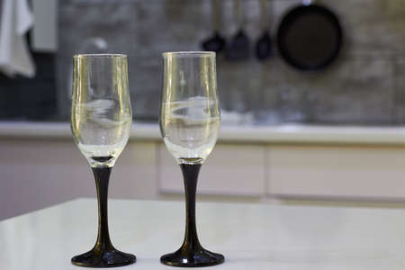 Empty champagne glasses close up on the table in a beautiful modern kitchenの写真素材